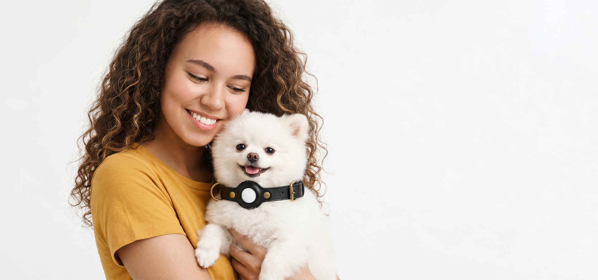 Smiling woman hugging small dog wearing tracking collar EDEN.slider_item_YqejQX
